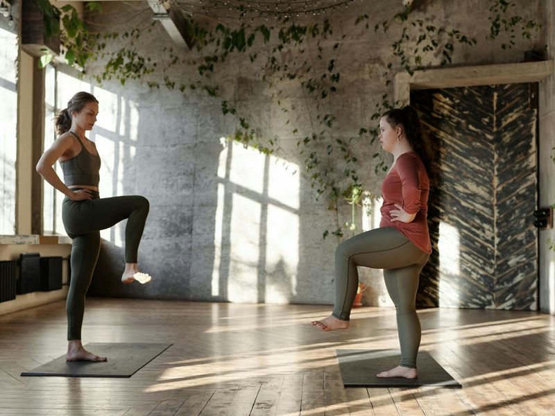 Beautiful sunlit yoga studio with wooden floors and plants